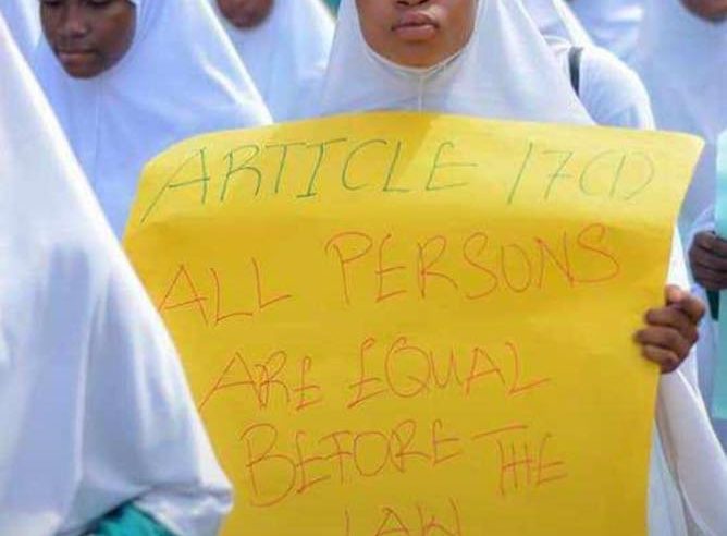 Young hijab walk participant passes on